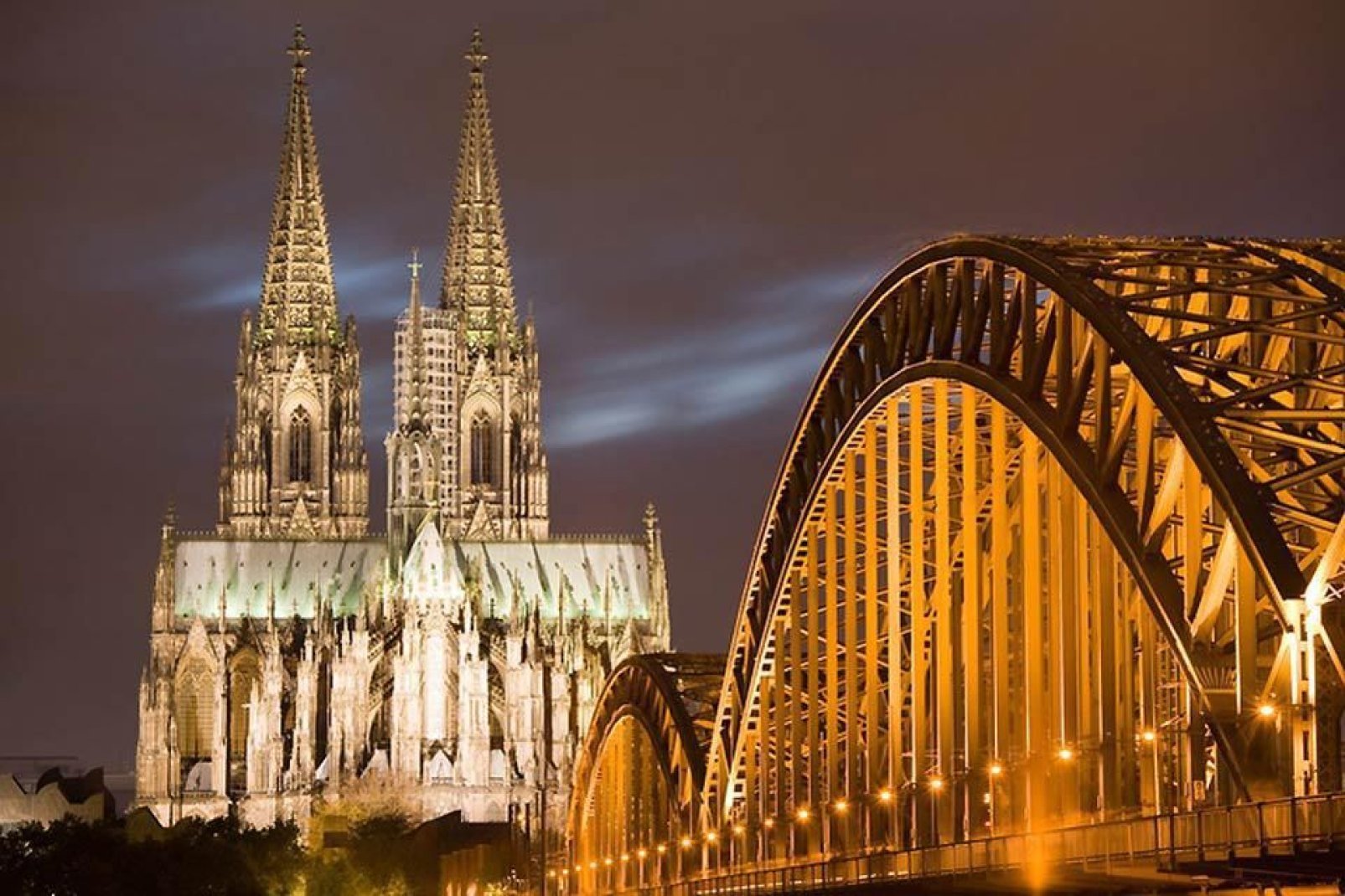 La cattedrale di Colonia e il ponte di Deutz sono illuminati magnificamente di notte.