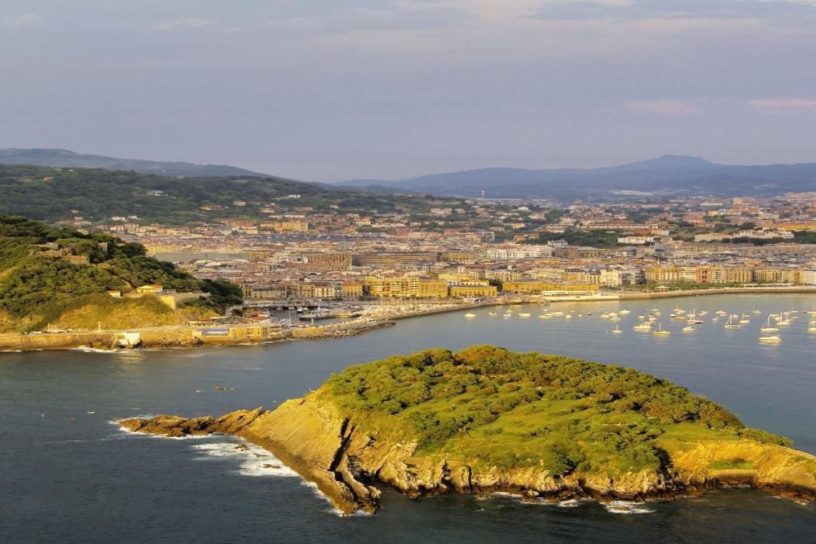 The city of San Sebastian stretches out from the mouth of the Urumea River around a bay dominated by Mounts Urgull, Igeldo and Ullia, and partly enclosed by Santa Clara Island.