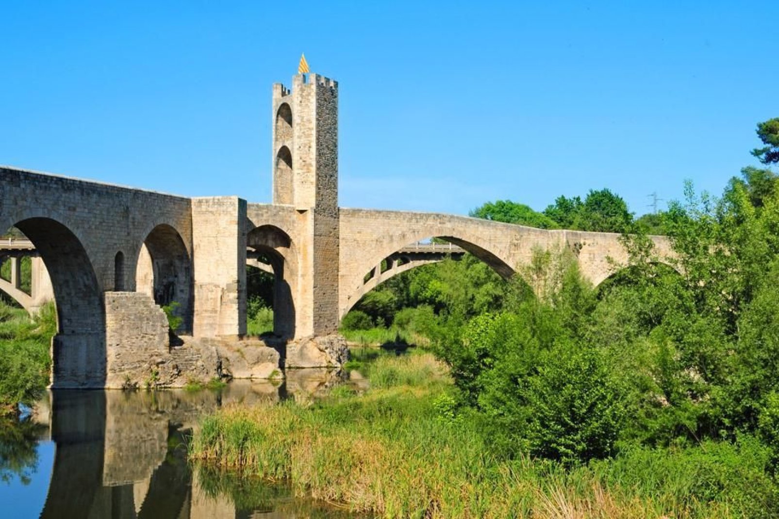 Per entrare nella città si attraversa un magnifico ponte romanico del XII secolo che sovrasta il fiume Fluvià.