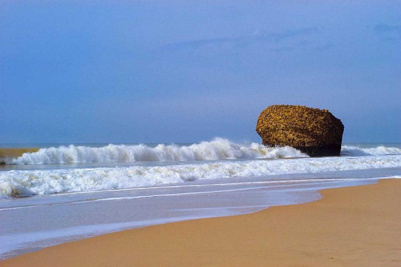 Dieser feinkörnige goldene Sandstrand ist von Felsen umgeben.