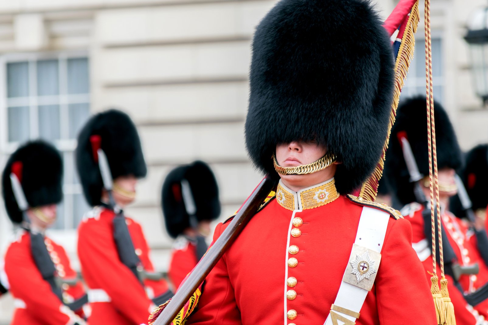 Cet uniforme typique composé d'une tunique rouge et d'un bonnet noir en poils d'ours est emprunté en 1831 à la garde impériale de Napoléon défaite à Waterloo, mais qui forçat l'admiration des Anglais. Aujourd'hui, il est question de remplacer les poils d'ours par du synthétique.