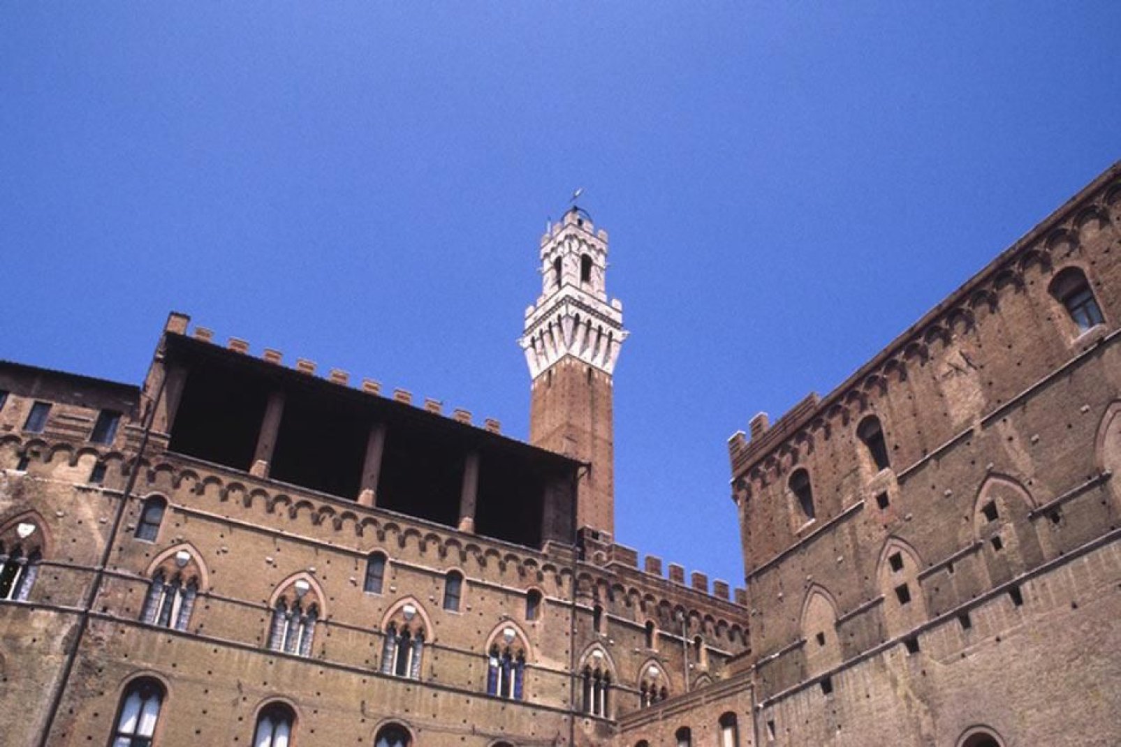 Torre del Mangia (Froschperspektive). Es handelt sich um den Belfried des Palazzo Publico, dessen Name auf den Spitznamen "Mangiaguadagni" des allerersten Turmwächters zurückgeht.